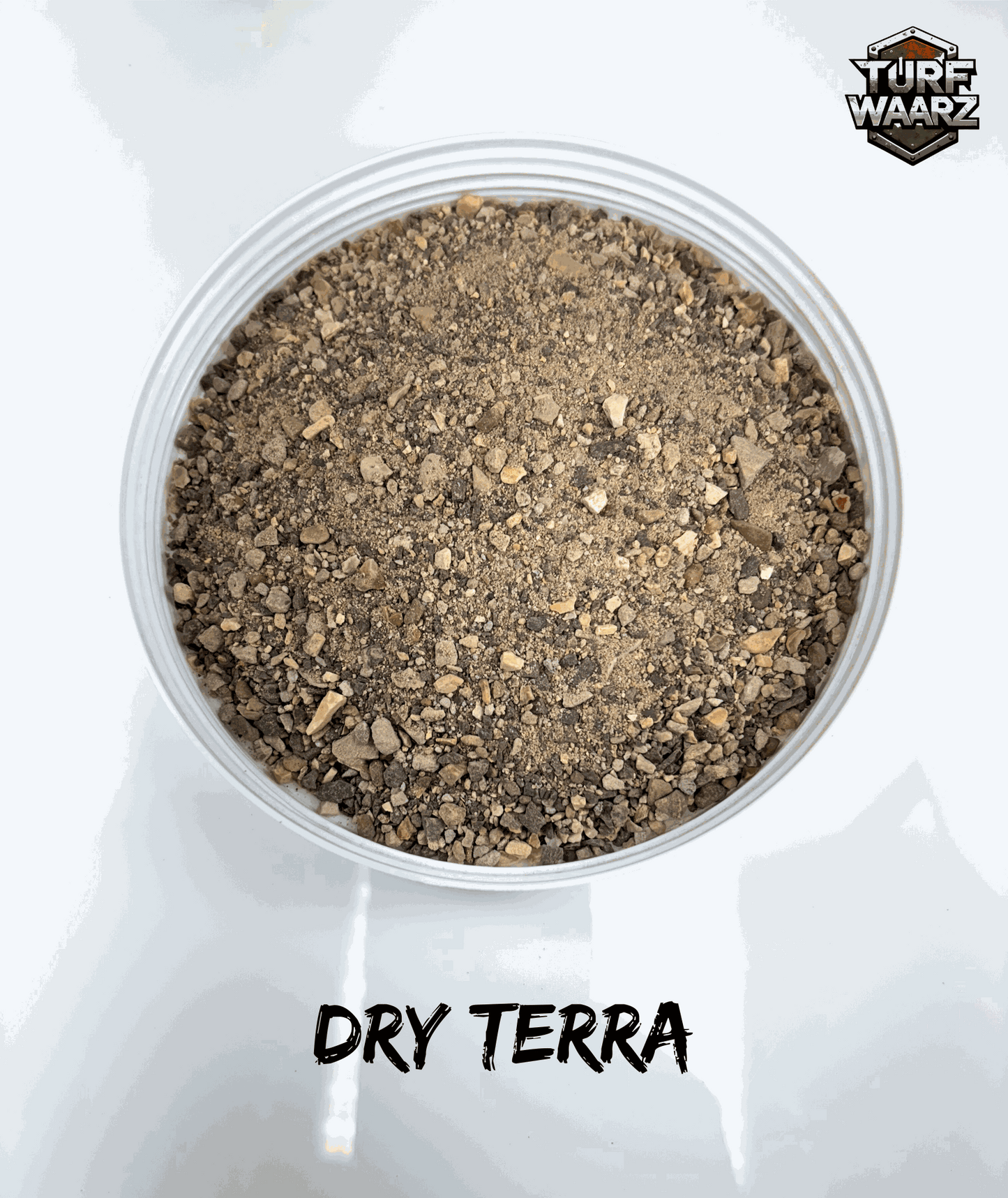 Turf Waarz Dry Terra Wargame Turf in clear plastic container with mixed gravel and sand for miniature wargame terrain modeling.