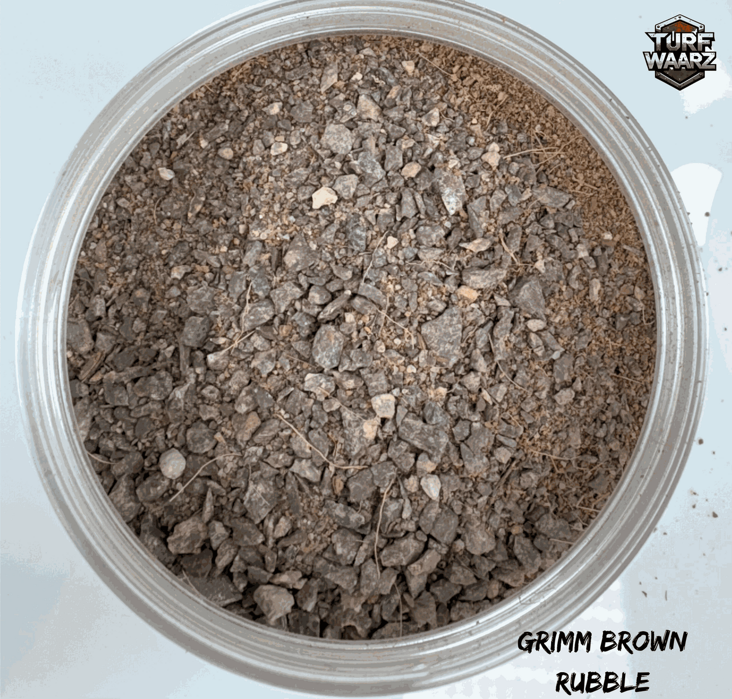 Turf Waarz Grimm Brown Rubble wargame terrain scatter with mixed gravels and sands in a clear plastic container.