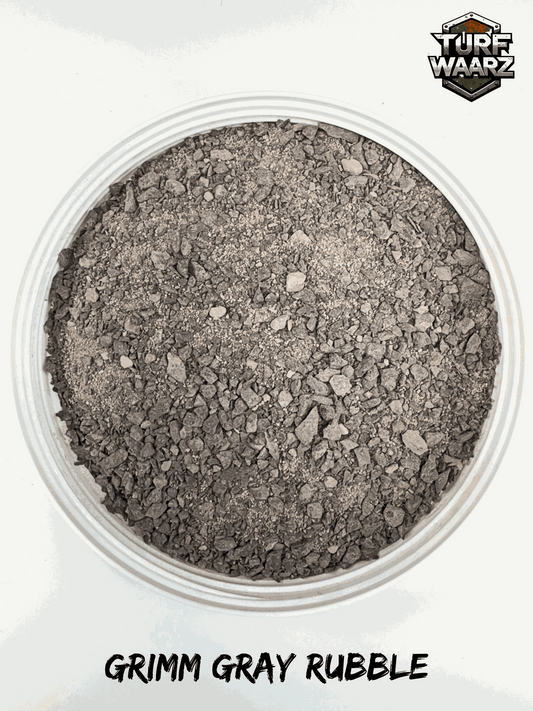 Turf Waarz Grimm Gray Rubble wargame terrain material in a clear plastic container, showing gray gravel and rubble texture for miniature and tabletop modeling