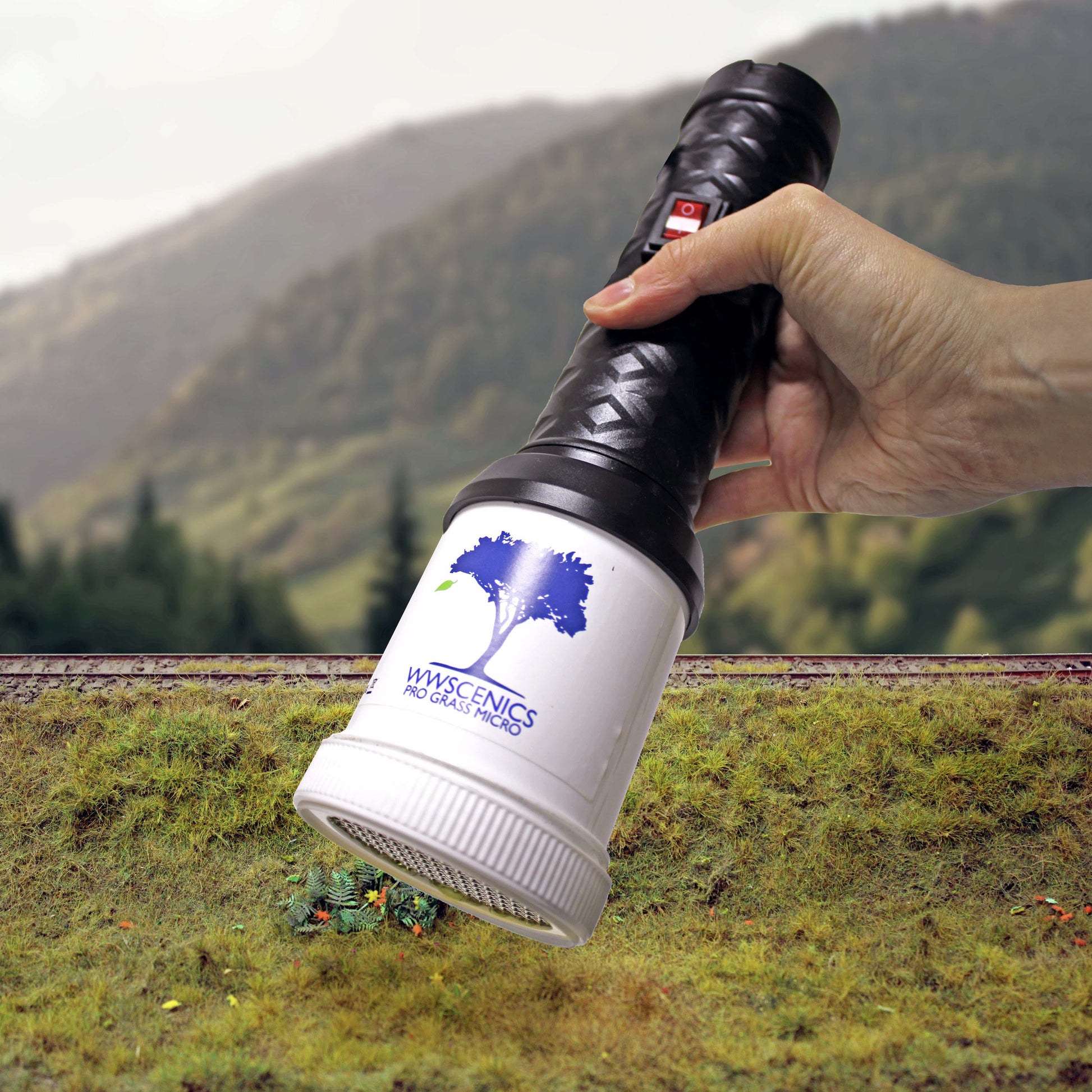 WWScenics Pro Grass Micro Static Grass Applicator held over a miniature landscape for detailed model grass application