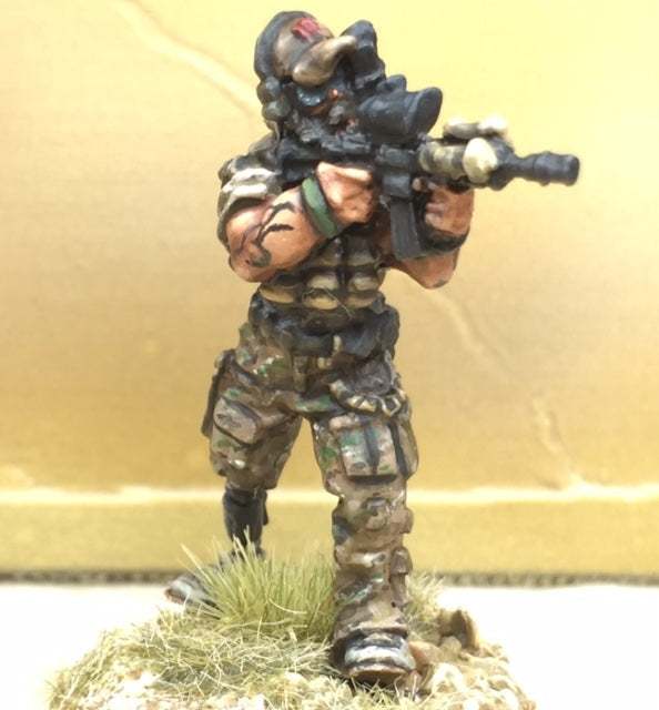 28mm Special Operator miniature figure with camouflage gear and prosthetic leg aiming rifle on grass base