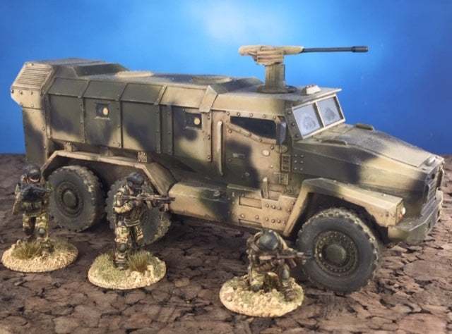28mm modern Ural Typhoon 1/50 scale resin and metal model military vehicle with three soldier miniatures on cracked terrain