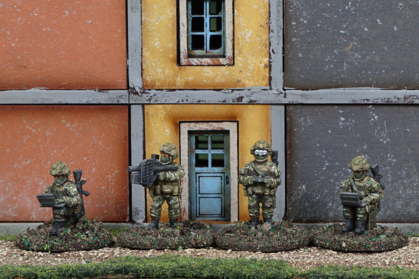 15mm modern Ukrainian fighter pack metal miniature soldiers in camo gear with assault rifles and equipment displayed in front of painted building facade