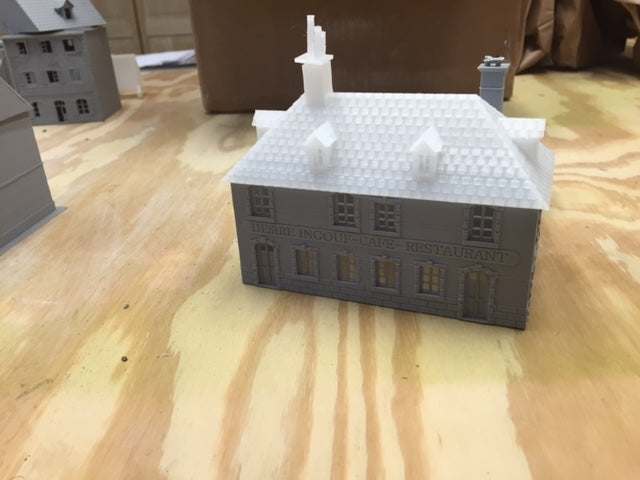 3D printed Caretan3 Kit scaled model building on wooden surface for tabletop gaming or display.