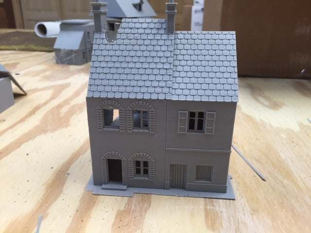 Caretan7 miniature gray model house with detailed windows and roof on wooden surface