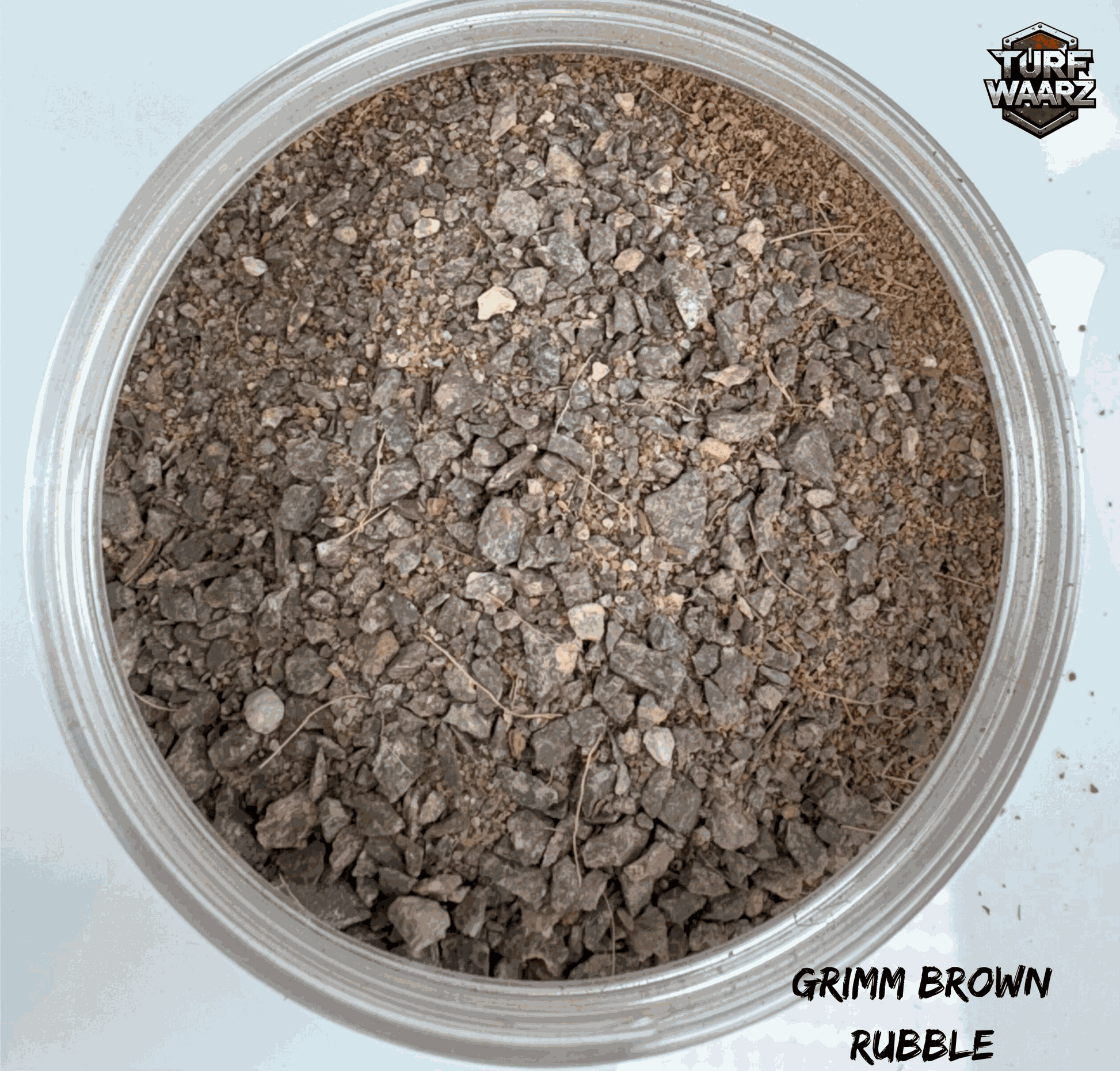Turf Waarz Grimm Brown Rubble wargame terrain scatter with mixed gravels and sands in a clear plastic container.