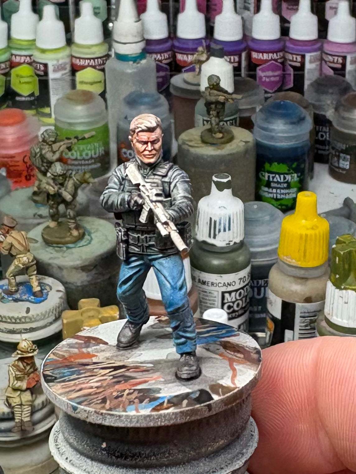 32mm Special Forces Extractor miniature figure unpainted on display base surrounded by paint bottles