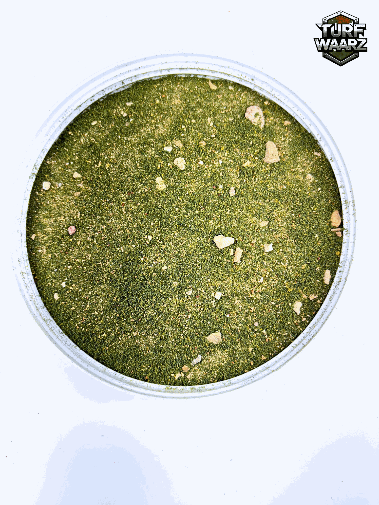 Turf Waarz Mini Scale Rocky Grass Wargame Turf in a plastic container, showing detailed green and rocky textured terrain for miniature wargaming and modeling.