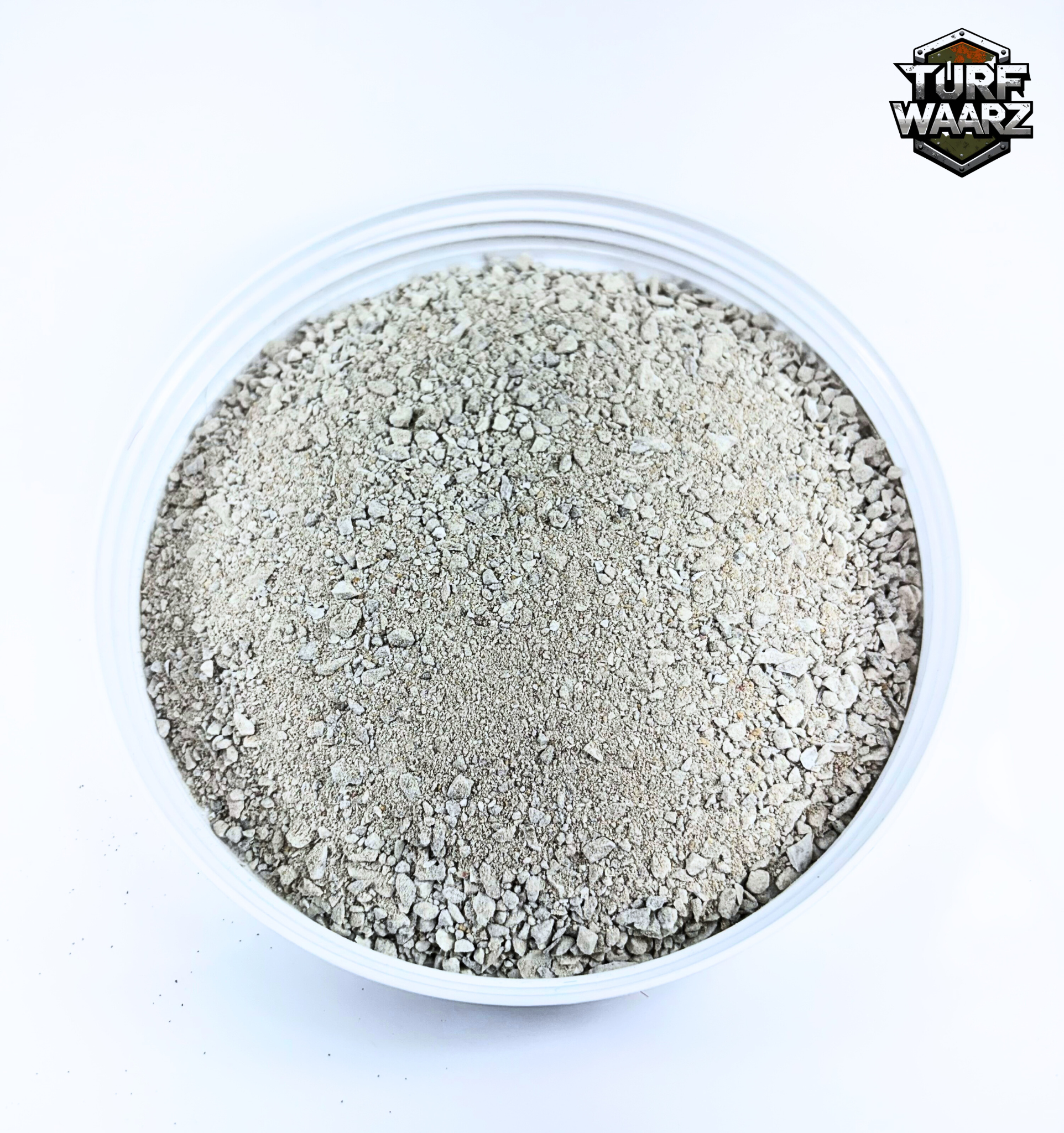 Gray Urban Rubble wargame terrain material in a clear plastic container for modeling and tabletop games
