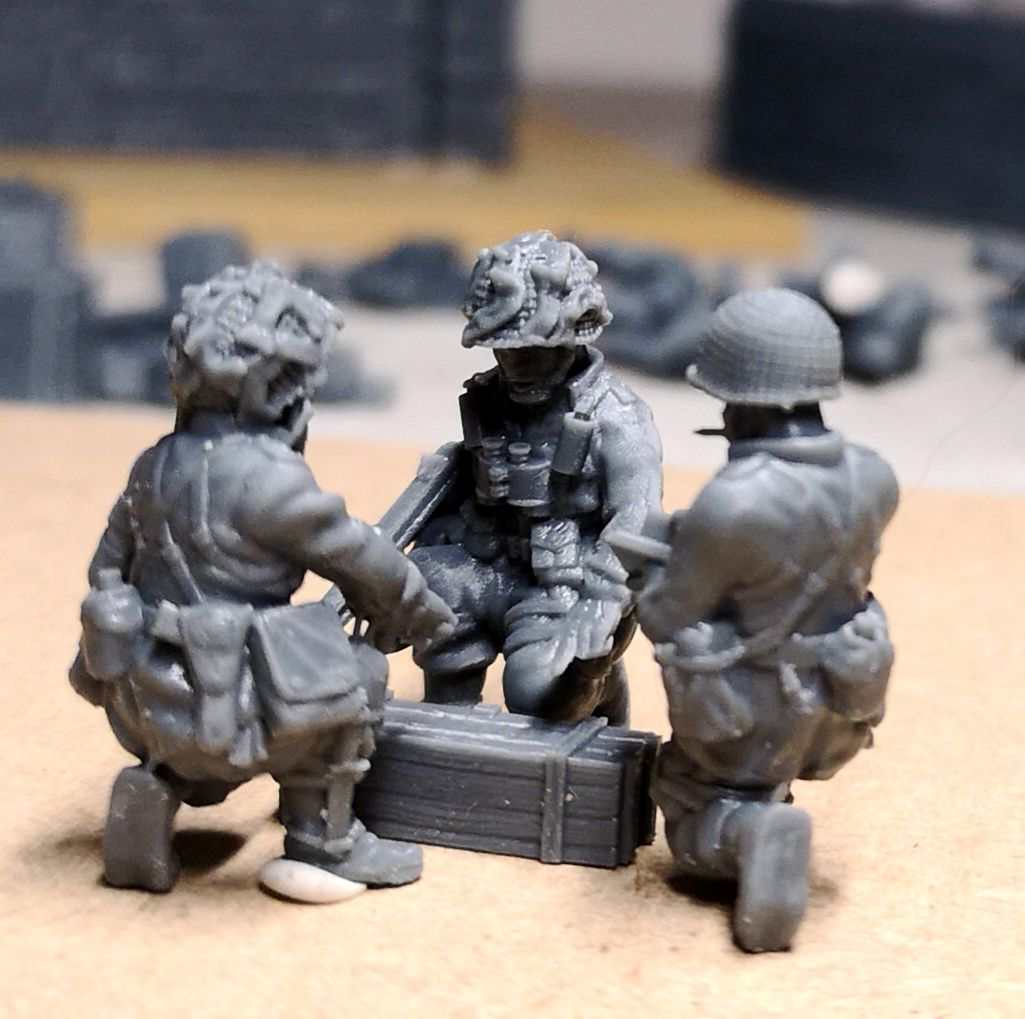 28mm WW2 US paratroopers command group miniatures in briefing pose around an ammunition crate