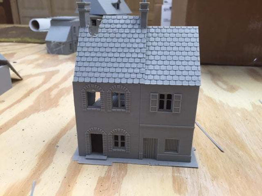 Caretan7 miniature gray model house with detailed windows and roof on wooden surface